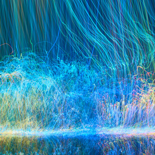 Defocused luminous colored stripes in an abstract chaotic pattern to suggest energy flow.